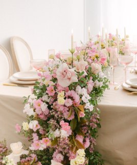 Table dressée avec un chemin de fleurs roses